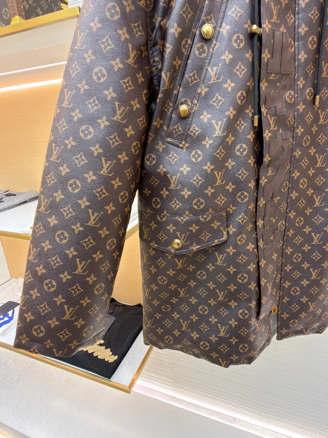 LOUIS VUITTON letter print hooded jacket ●Original version: Purchased and developed for 69999 ●Item number: 1681985-E40 ●Fabric: cotton fabric ●Technology: printing production ●Color: brown ●Version: fitted version ●Weight: about 1810 grams ●Size: 46-48-50-52 ●Description: This printed jacket is made of embossed leather fabric with a dark brown base and is fully printed with the classic Monogram pattern. The embossing process gives the logo a three-dimensional texture. The edge of the hood is spliced ​​with a natural fur collar, and the brim is equipped with an adjustable drawstring (metal rope buckle) to enhance warmth and style. The placket is double-closed with a two-way metal zipper and brass snap buttons. The zipper puller and snap button are both engraved with the brand logo, which is thick and durable. The body is designed with multiple pockets, and the pockets are edged with the same material + metal snap buttons for reinforcement. The left sleeve is equipped with a hidden adjustment tab. The interior is filled with high-fill down cotton, and the stitching adopts diamond-shaped quilting technology to prevent the filling from shifting. The seams are edged with leather of the same color, and the overall wiring is precise, taking into account warmth retention and luxurious texture. The overall wiring is straight and delicate, the fabric is comfortable and soft, and the color is consistent without color difference. It can be matched with the same style to create a fashionable look and control various occasions. Customized accessories, complete with three standards, same style for men and women!